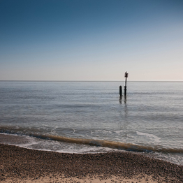 Seascape, shingle beach in the foreground with gentle waves from the sea